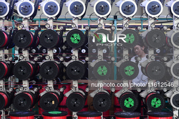 A worker works on a paper-making net production line at Pacific Special Mesh Co., LTD in Fuyang, China, on September 27, 2024. 