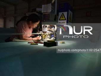 A worker works on a paper-making net production line at Pacific Special Mesh Co., LTD in Fuyang, China, on September 27, 2024. (