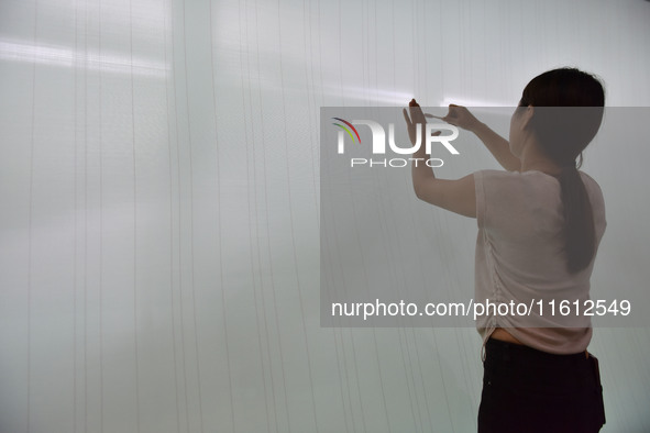 A worker checks the quality of paper-making nets at Pacific Special Nets Co., LTD in Fuyang, China, on September 27, 2024. 