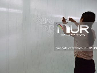 A worker checks the quality of paper-making nets at Pacific Special Nets Co., LTD in Fuyang, China, on September 27, 2024. (