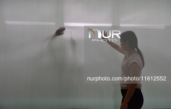 A worker checks the quality of paper-making nets at Pacific Special Nets Co., LTD in Fuyang, China, on September 27, 2024. 