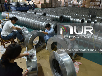 A worker cleans a tray at Pacific Special Mesh Industry Co., LTD in Fuyang, China, on September 27, 2024. (