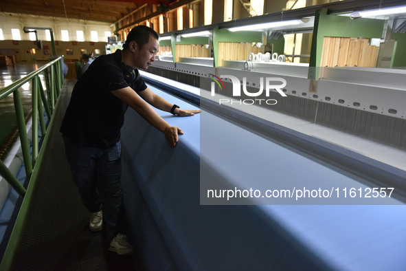 A worker operates a mesh machine at Pacific Special Mesh Industry Co., LTD in Fuyang, China, on September 27, 2024. 