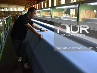 A worker operates a mesh machine at Pacific Special Mesh Industry Co., LTD in Fuyang, China, on September 27, 2024. (