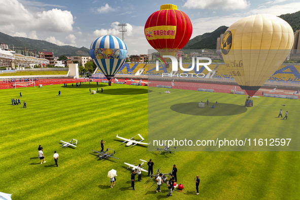 Hot air balloons and drones are displayed at the event of the China International Aircraft Design Challenge 2024 (Fujian Station) at the New...