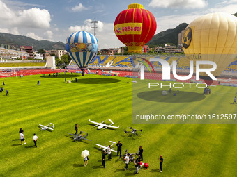 Hot air balloons and drones are displayed at the event of the China International Aircraft Design Challenge 2024 (Fujian Station) at the New...