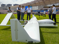 Aviation enthusiasts look at drones at the event site of the 2024 China International Aircraft Design Challenge (Fujian Station) at the new...