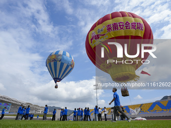 Aviation enthusiasts experience a hot air balloon ride at the event site of the 2024 China International Aircraft Design Challenge (Fujian S...