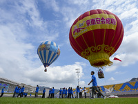 Aviation enthusiasts experience a hot air balloon ride at the event site of the 2024 China International Aircraft Design Challenge (Fujian S...