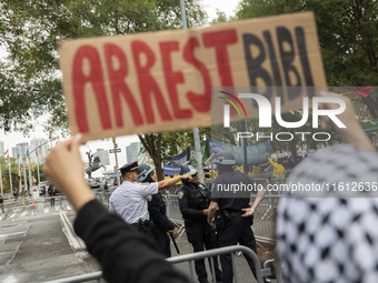 A pro-Palestinian demonstrator shows a sign with the words ''Arrest Bibi'' during a protest in front of the United Nations (UN) headquarters...