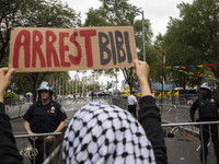 A pro-Palestinian demonstrator shows a sign with the words ''Arrest Bibi'' during a protest in front of the United Nations (UN) headquarters...