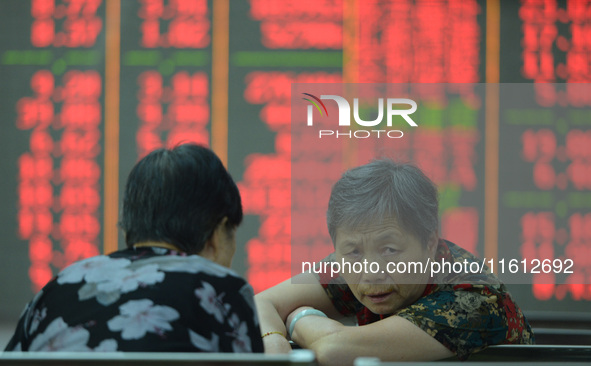 A customer pays attention to the stock market at a stock exchange in Hangzhou, China, on September 27, 2024. On the same day, affected by th...