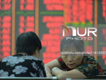 A customer pays attention to the stock market at a stock exchange in Hangzhou, China, on September 27, 2024. On the same day, affected by th...