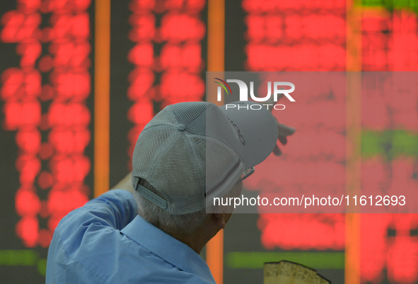 A customer pays attention to the stock market at a stock exchange in Hangzhou, China, on September 27, 2024. On the same day, affected by th...