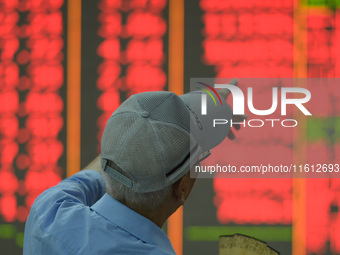 A customer pays attention to the stock market at a stock exchange in Hangzhou, China, on September 27, 2024. On the same day, affected by th...