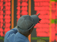 A customer pays attention to the stock market at a stock exchange in Hangzhou, China, on September 27, 2024. On the same day, affected by th...