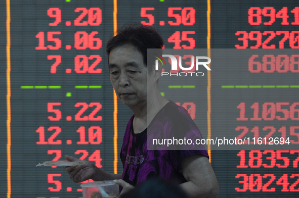 A customer pays attention to the stock market at a stock exchange in Hangzhou, China, on September 27, 2024. On the same day, affected by th...