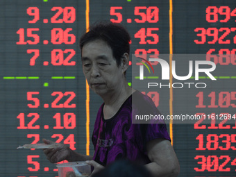 A customer pays attention to the stock market at a stock exchange in Hangzhou, China, on September 27, 2024. On the same day, affected by th...