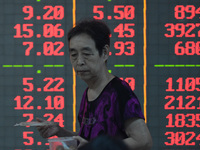 A customer pays attention to the stock market at a stock exchange in Hangzhou, China, on September 27, 2024. On the same day, affected by th...