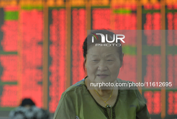 A customer pays attention to the stock market at a stock exchange in Hangzhou, China, on September 27, 2024. On the same day, affected by th...