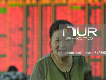 A customer pays attention to the stock market at a stock exchange in Hangzhou, China, on September 27, 2024. On the same day, affected by th...