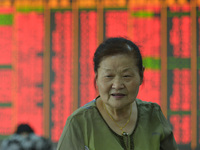 A customer pays attention to the stock market at a stock exchange in Hangzhou, China, on September 27, 2024. On the same day, affected by th...