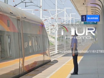 A staff member receives and departs a train on the platform at Fushan Station in Yantai, China, on September 27, 2024. As of September 14, 2...