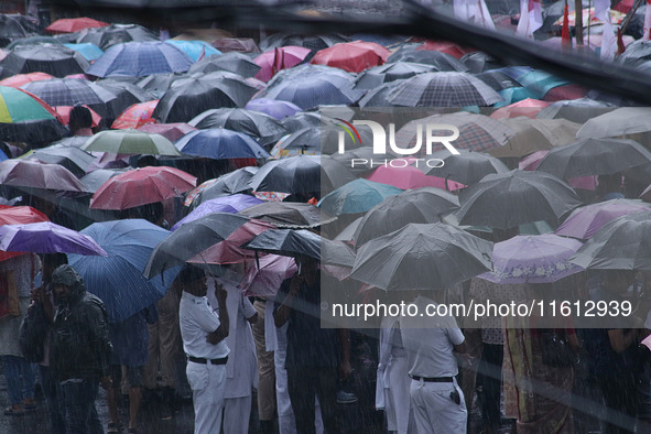 People protest amid heavy rain during a rally against the rape and murder of a PGT woman doctor at the government-run R G Kar Medical Colleg...