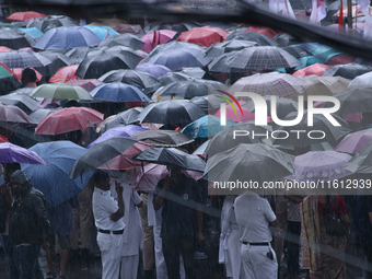 People protest amid heavy rain during a rally against the rape and murder of a PGT woman doctor at the government-run R G Kar Medical Colleg...