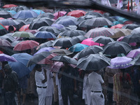 People protest amid heavy rain during a rally against the rape and murder of a PGT woman doctor at the government-run R G Kar Medical Colleg...