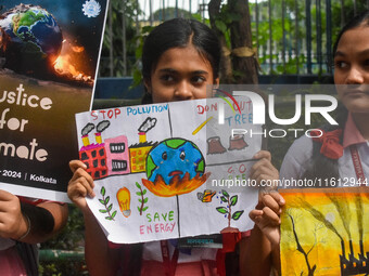 Students display their paintings dedicated to the protection of the global climate during the Global Climate Strike 2024 in Kolkata, India,...