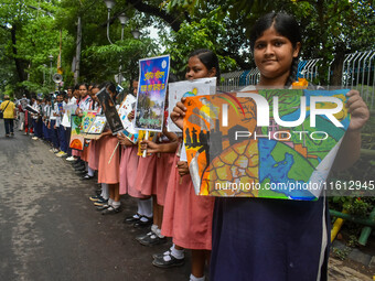 Students display their paintings dedicated to the protection of the global climate during the Global Climate Strike 2024 in Kolkata, India,...