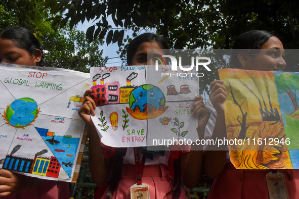 Students display their paintings dedicated to the protection of the global climate during the Global Climate Strike 2024 in Kolkata, India,...