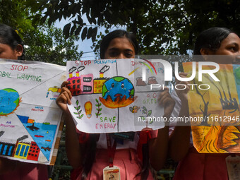 Students display their paintings dedicated to the protection of the global climate during the Global Climate Strike 2024 in Kolkata, India,...