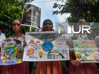 Students display their paintings dedicated to the protection of the global climate during the Global Climate Strike 2024 in Kolkata, India,...