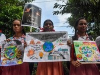 Students display their paintings dedicated to the protection of the global climate during the Global Climate Strike 2024 in Kolkata, India,...