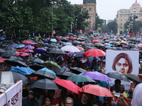 People protest amid heavy rain during a rally against the rape and murder of a PGT woman doctor at the government-run R G Kar Medical Colleg...