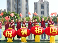 Students of Chuzhou No. 4 Primary School in Chuzhou, China, on September 27, 2024, carry red lanterns printed with the words ''Bless the mot...