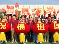 Students of Chuzhou No. 4 Primary School in Chuzhou, China, on September 27, 2024, carry red lanterns printed with the words ''Bless the mot...