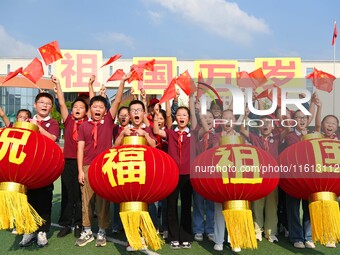 Students of Chuzhou No. 4 Primary School in Chuzhou, China, on September 27, 2024, carry red lanterns printed with the words ''Bless the mot...