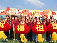 Students of Chuzhou No. 4 Primary School in Chuzhou, China, on September 27, 2024, carry red lanterns printed with the words ''Bless the mot...