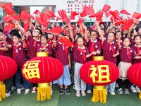 Students of Chuzhou No. 4 Primary School in Chuzhou, China, on September 27, 2024, carry red lanterns printed with the words ''Bless the mot...