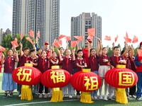 Students of Chuzhou No. 4 Primary School in Chuzhou, China, on September 27, 2024, carry red lanterns printed with the words ''Bless the mot...