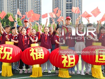 Students of Chuzhou No. 4 Primary School in Chuzhou, China, on September 27, 2024, carry red lanterns printed with the words ''Bless the mot...