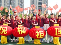 Students of Chuzhou No. 4 Primary School in Chuzhou, China, on September 27, 2024, carry red lanterns printed with the words ''Bless the mot...