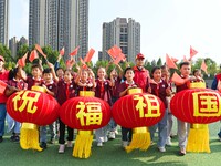 Students of Chuzhou No. 4 Primary School in Chuzhou, China, on September 27, 2024, carry red lanterns printed with the words ''Bless the mot...