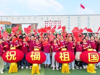 Students of Chuzhou No. 4 Primary School in Chuzhou, China, on September 27, 2024, carry red lanterns printed with the words ''Bless the mot...