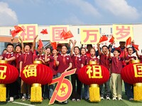 Students of Chuzhou No. 4 Primary School in Chuzhou, China, on September 27, 2024, carry red lanterns printed with the words ''Bless the mot...