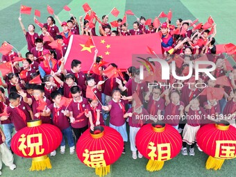 Students of Chuzhou No. 4 Primary School in Chuzhou, China, on September 27, 2024, carry red lanterns printed with the words ''Bless the mot...