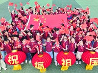 Students of Chuzhou No. 4 Primary School in Chuzhou, China, on September 27, 2024, carry red lanterns printed with the words ''Bless the mot...